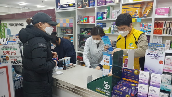 약국지원 봉사단이 공적마스크 판매 약국    에서 마스크판매를 돕고 있다