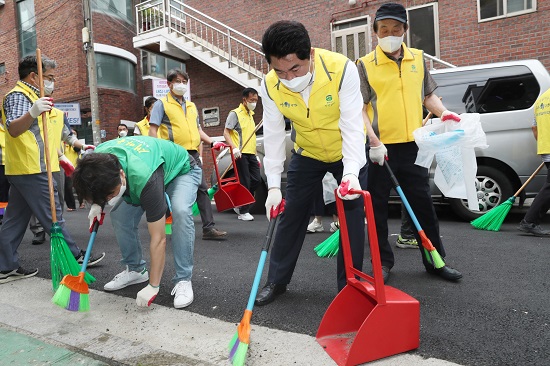 박준희 구청장이 자율청소봉사단원들과 함께 난곡동 골목길을 청소하고 있다