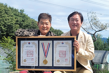 트로트가수 진성(왼쪽)이 신지식인 인증패를 전달받고 한국신지식인협회 김종백 중앙회장(오른쪽)과 기념촬영 하는 모습.