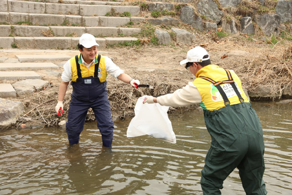 신천지자원봉사단 서울동부지부 회원들이 당현천 물 안에 쓰레기를 줍고 있다.